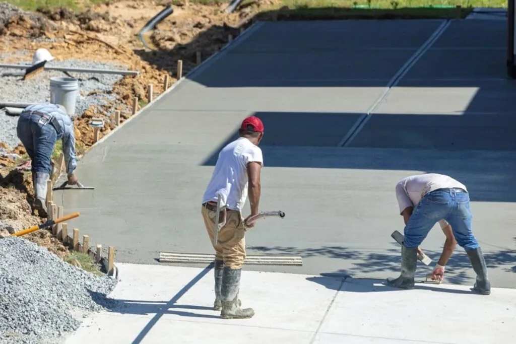 team of concrete contractor finishing concrete driveway installation 